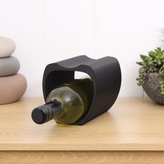 a wine bottle holder sitting on top of a wooden table next to a succulent plant