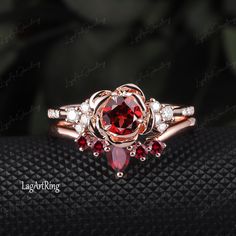 a close up view of a ring with red stones and diamonds on the side,