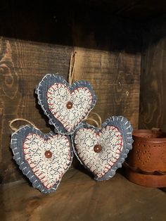 three heart shaped ornaments are sitting on a shelf