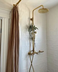 a shower head and hand held shower faucet in a bathroom with white tile walls