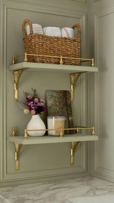 the shelves in the bathroom are decorated with gold and white decor, such as flowers