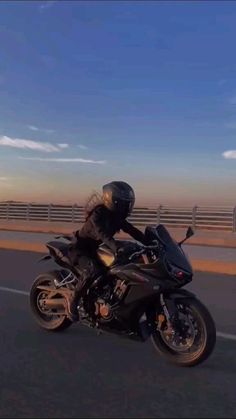 a man riding on the back of a motorcycle down a highway