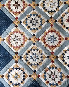 a blue and white quilt with many different designs on it's sides, including stars