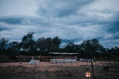 a table set up for an outdoor dinner in the middle of a field at night