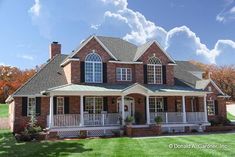 a large brick house in the middle of a green field