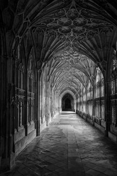 the inside of an old building with stone floors and arches in black and white photo