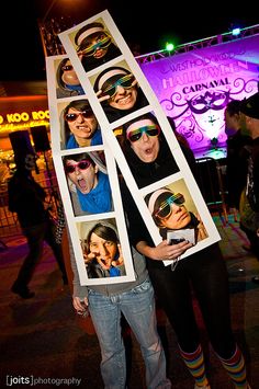 two people standing next to each other with pictures on their clothes and holding up signs