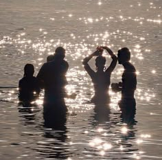 some people are in the water and one is raising his hat