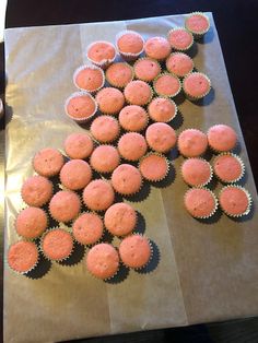 some pink cupcakes are on a brown paper bag