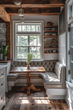 a room with a couch, table and shelves in the corner next to a window