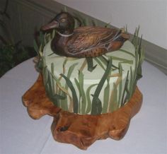 there is a cake that has a duck on it and grass in front of it