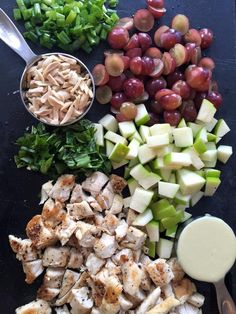 grapes, chicken, celery, and other ingredients are arranged on a cutting board