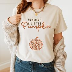 a woman wearing a t - shirt that says growing pumpkin