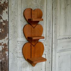 two wooden heart shaped shelves mounted to the side of a wall