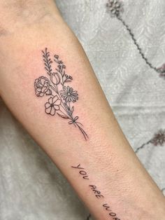 a woman's arm with flowers and the words i love you to the moon and back