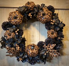 a leopard print wreath hanging on a wooden door