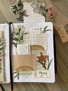 an open notebook with paper and flowers on it