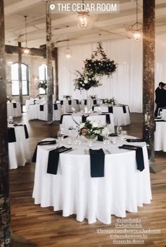 a room filled with tables covered in white and black cloths