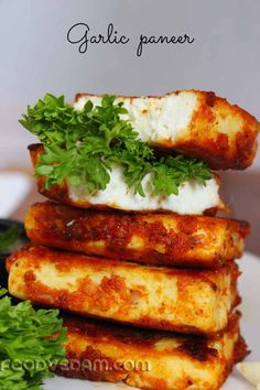 some food is stacked on top of each other with sauce and parsley in the middle