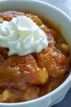 a close up of a bowl of food with whipped cream on top