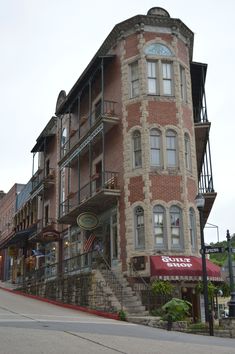 an old brick building with stairs leading up to the top floor and second story windows