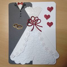 two wedding cards with red and white hearts on them, one has a pair of scissors