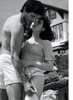 black and white photograph of a man kissing a woman's cheek on the beach