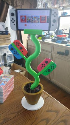 a cell phone is on top of a potted plant with game controllers in it