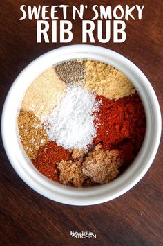 a bowl filled with different colored spices on top of a wooden table next to the words sweet n'smoky rib rub