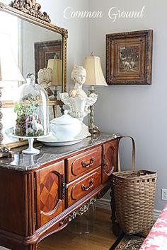 a table with a mirror, lamp and vase on it