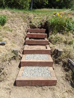 a set of steps made out of bricks in the middle of some grass and dirt