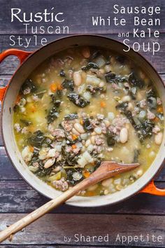 a pot filled with white bean and kale soup on top of a wooden table