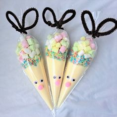 three plastic cones with candies in the shape of mice and bunny ears on them