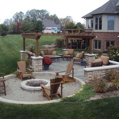 an outdoor patio with chairs, fire pit and seating area in the middle of it