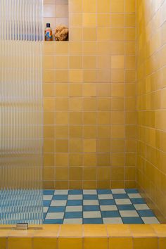 a yellow tiled shower with blue and white tiles