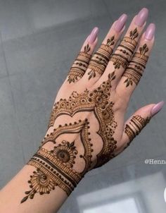 a woman's hand with henna tattoos on it