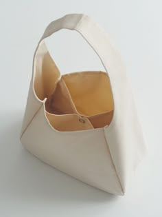 an open white bag on top of a white surface with the bottom half folded up