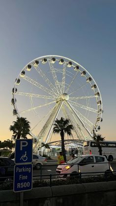 a large ferris wheel sitting next to a parking lot