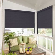 a living room filled with furniture and windows covered in shades