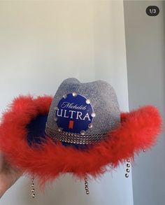 a person holding a hat with red feathers around it and the words happy birthday ultra on it