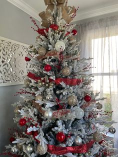 a white christmas tree with red and silver ornaments