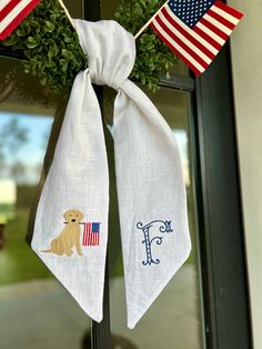 two flags hang from the front door of a home with a dog and flag on it