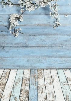 an old wood plank wall with white flowers on it and a blue wooden floor in the background