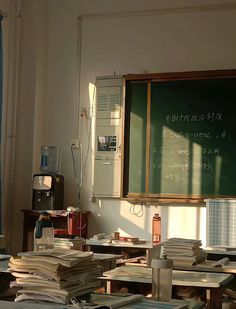 a classroom filled with lots of books next to a chalkboard