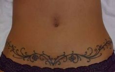 a woman's stomach with an intricate tattoo on her lower body and bottom part