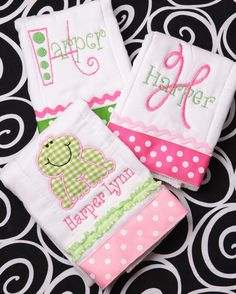 two personalized hand towels sitting on top of a black and white patterned table cloth