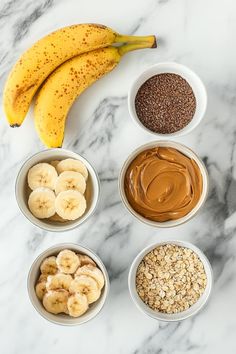 bananas, peanut butter, and other ingredients in bowls on a marble surface