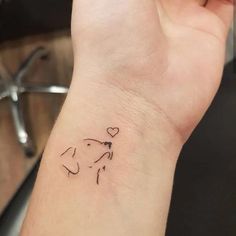 a small dog tattoo on the wrist