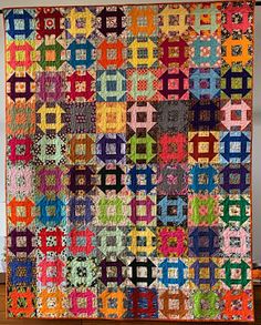 a colorful quilt hanging on the wall