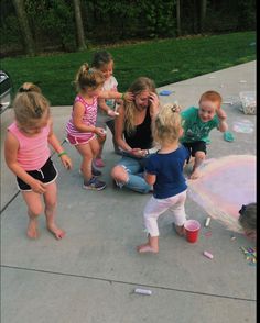 a group of young children standing around each other in front of a chalk drawing circle